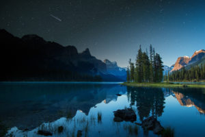 A shooting star goes over Spirit Island on Maligne Lake in Jasper, Alberta, Canada.